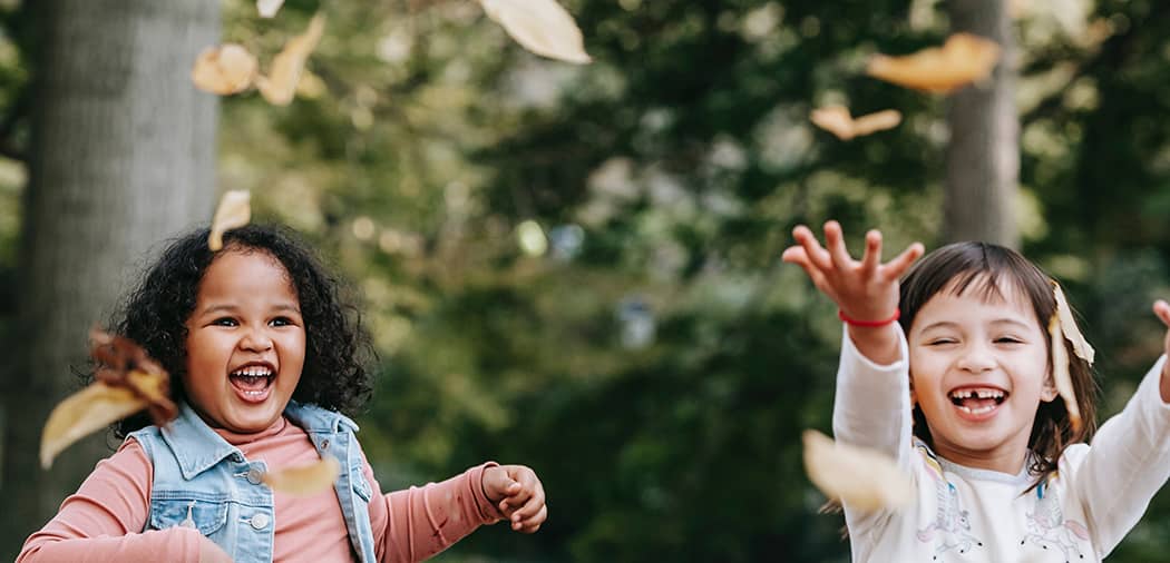 A representational image for surrender quotes featuring happy, carefree children playing with falling leaves